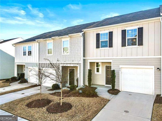 townhome / multi-family property with an attached garage, board and batten siding, and concrete driveway