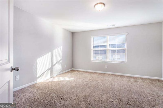 spare room with light carpet and baseboards