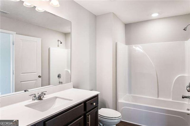 bathroom with visible vents, shower / bathing tub combination, vanity, and toilet