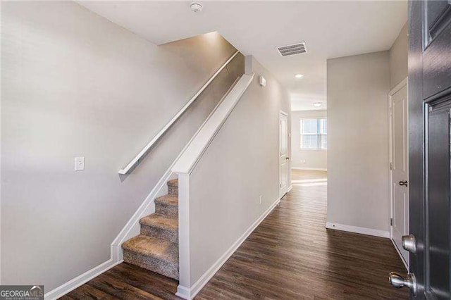 stairs featuring wood finished floors, visible vents, and baseboards