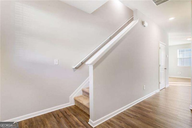 stairs with visible vents, baseboards, and wood finished floors