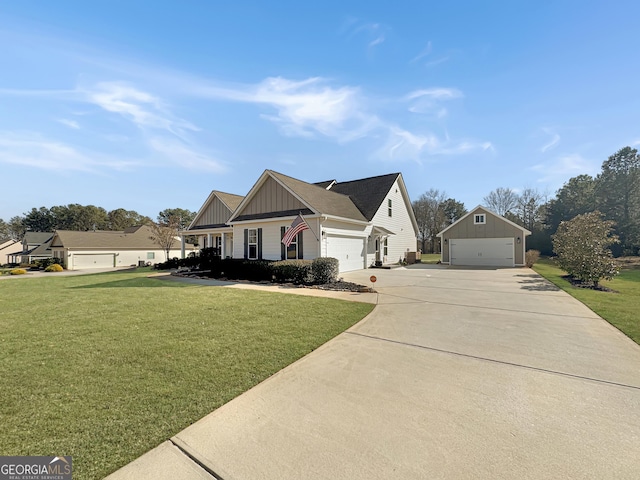 view of front of home featuring a front yard, concrete driveway, an outbuilding, and board and batten siding