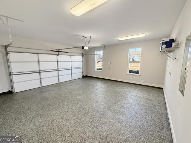 garage featuring a garage door opener and baseboards