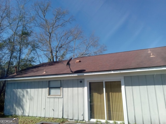 view of property exterior with board and batten siding and a shingled roof