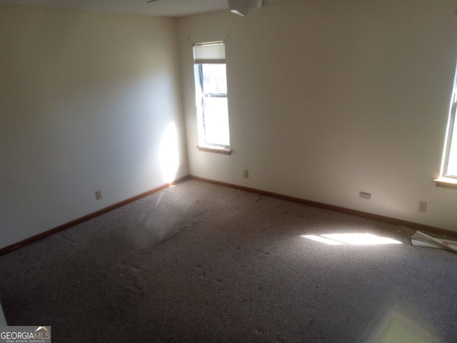 carpeted spare room featuring baseboards