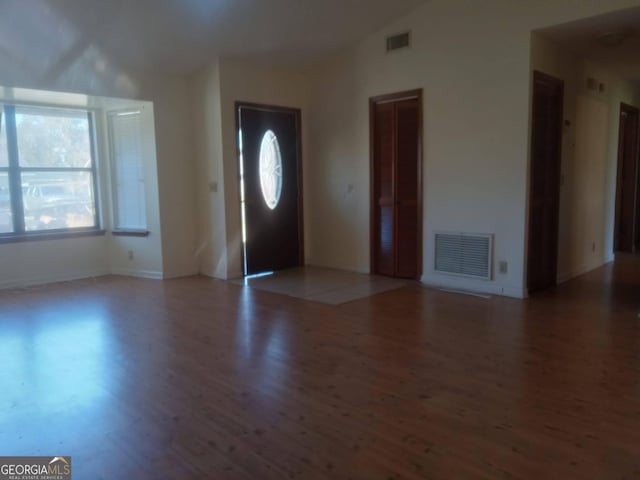 foyer with vaulted ceiling, wood finished floors, and visible vents