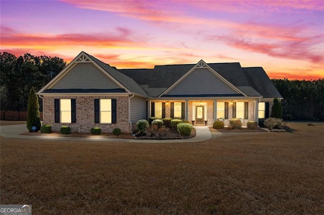 craftsman-style house with brick siding and a lawn