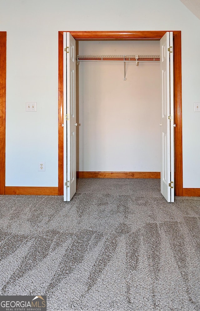 unfurnished bedroom with carpet floors, a closet, and baseboards