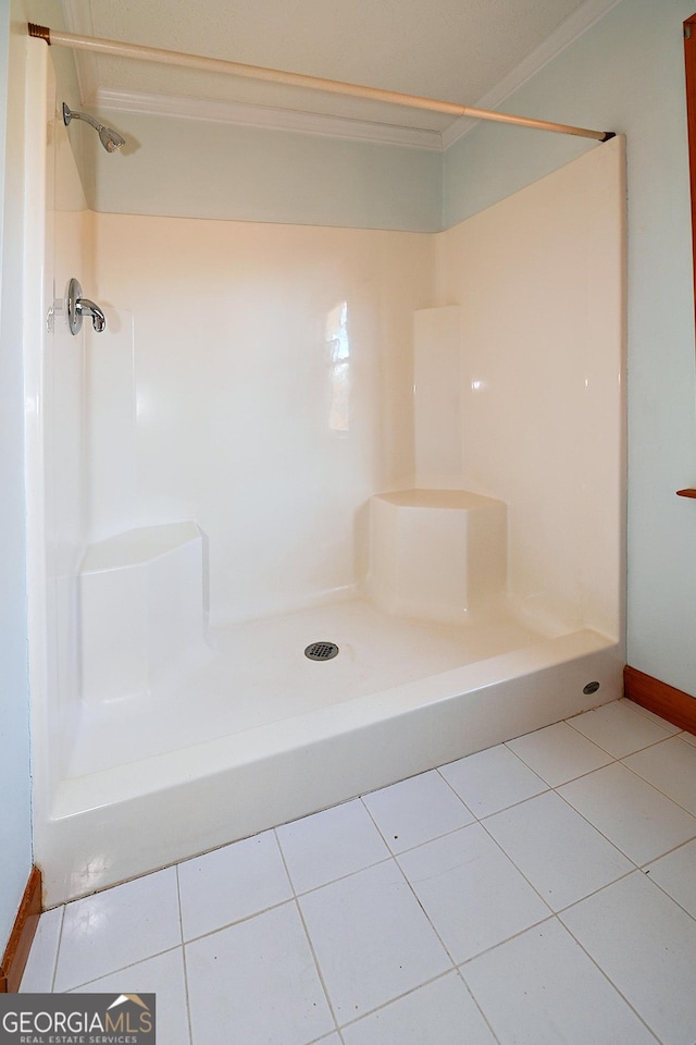 full bath featuring tile patterned flooring, ornamental molding, and walk in shower