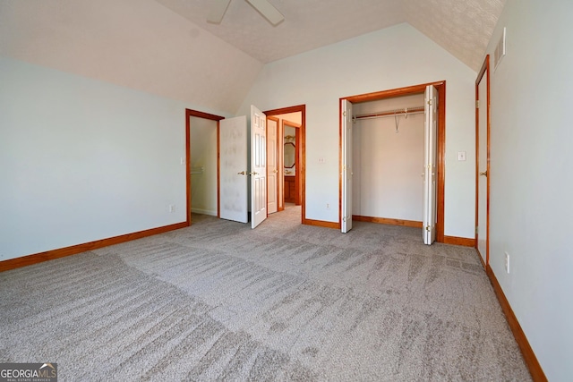 unfurnished bedroom with a closet, visible vents, light carpet, vaulted ceiling, and baseboards