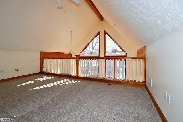 bonus room with a textured ceiling, carpet flooring, and a ceiling fan