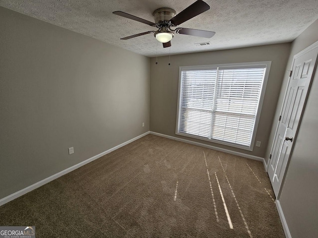 unfurnished bedroom featuring visible vents, dark carpet, and baseboards