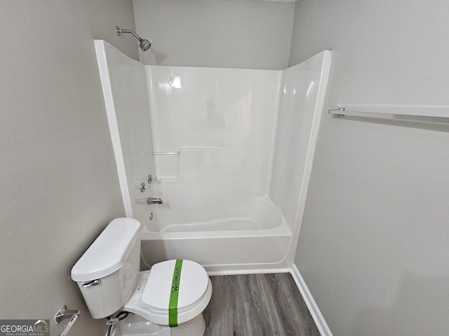 full bathroom featuring shower / bathing tub combination, wood finished floors, toilet, and baseboards