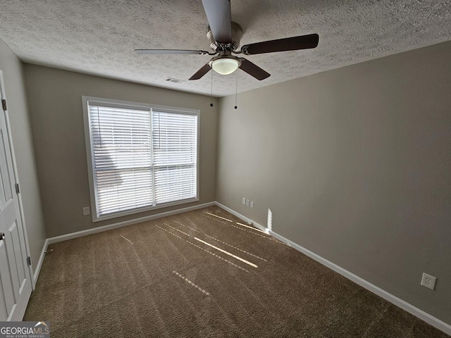 unfurnished room with dark colored carpet, visible vents, a ceiling fan, a textured ceiling, and baseboards