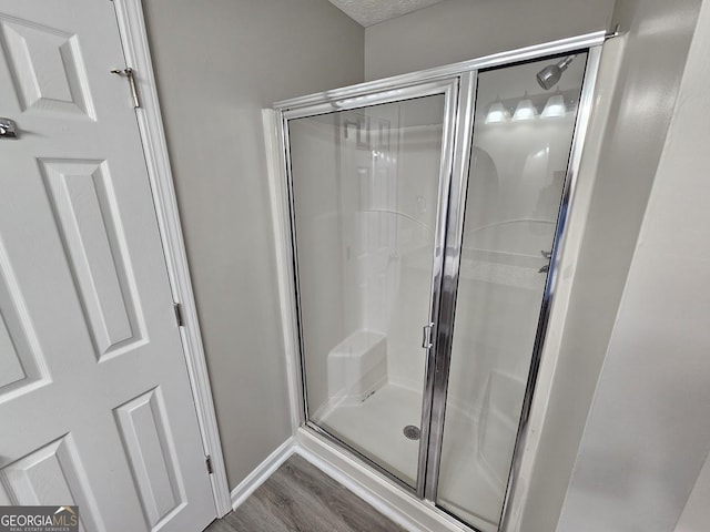 bathroom featuring a shower stall and wood finished floors