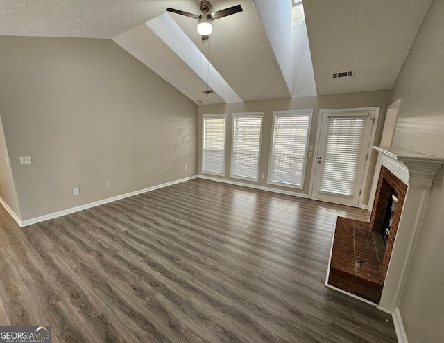 unfurnished living room with lofted ceiling, a fireplace, dark wood finished floors, and visible vents