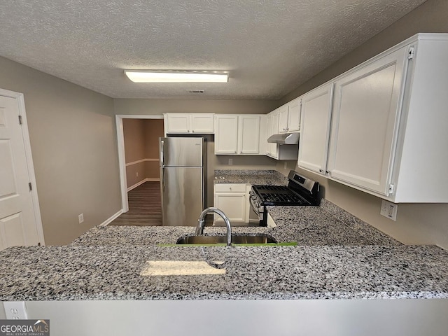 kitchen featuring stainless steel appliances, white cabinetry, a sink, and a peninsula