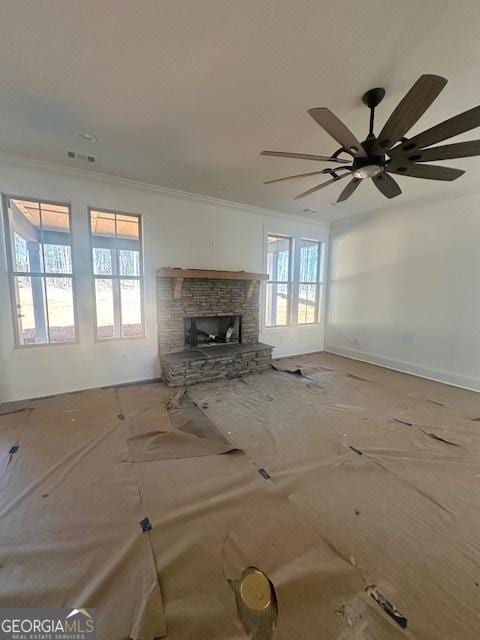 unfurnished living room with baseboards, visible vents, ornamental molding, and a stone fireplace