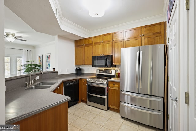 kitchen with dark countertops, brown cabinets, a sink, and black appliances