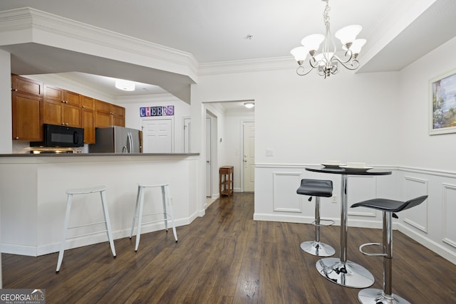 kitchen featuring white cabinets, dark wood-type flooring, freestanding refrigerator, black microwave, and pendant lighting