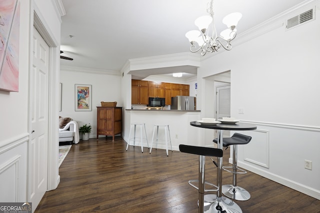 kitchen featuring dark wood finished floors, visible vents, brown cabinetry, freestanding refrigerator, and black microwave