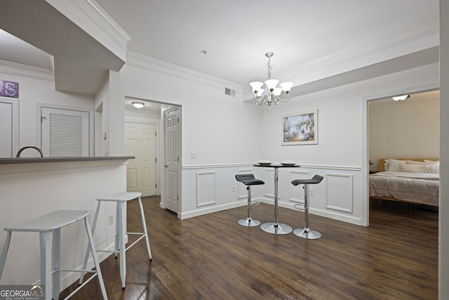 dining room featuring dark wood-style floors, a wainscoted wall, visible vents, and an inviting chandelier