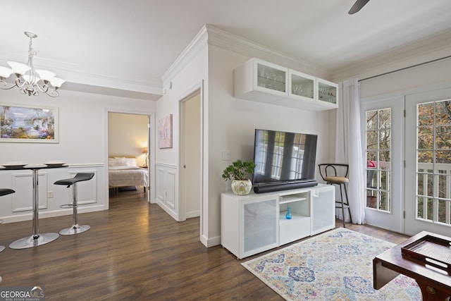 interior space featuring white cabinets, ornamental molding, dark wood finished floors, glass insert cabinets, and an inviting chandelier