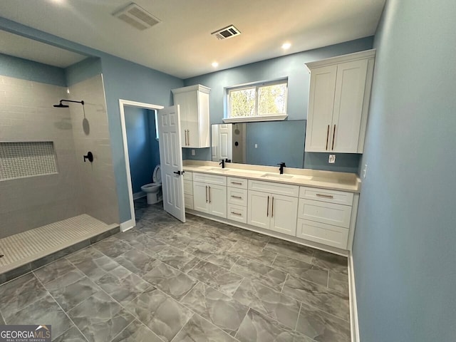 full bathroom with visible vents, a shower stall, toilet, and double vanity