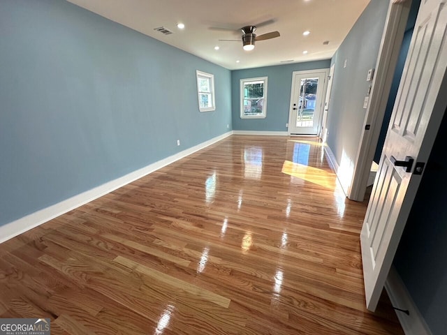 unfurnished room with recessed lighting, visible vents, a ceiling fan, light wood-type flooring, and baseboards