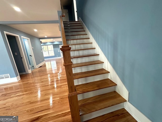 stairway with recessed lighting, wood finished floors, visible vents, and baseboards