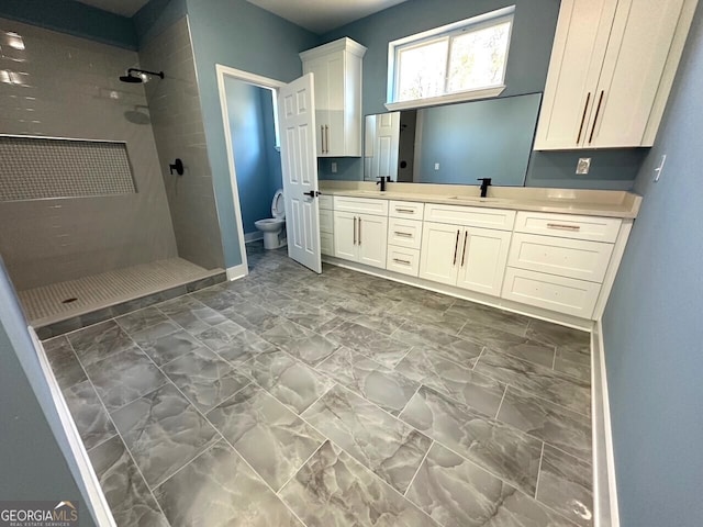 full bathroom with a stall shower, a sink, toilet, and double vanity