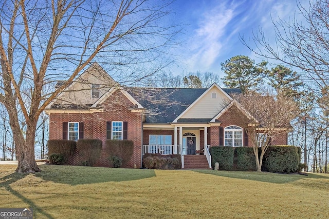 view of front of house featuring brick siding, a porch, and a front yard