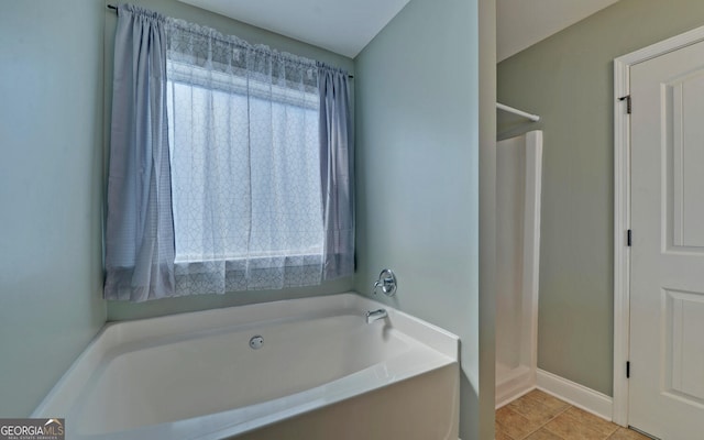 full bath with a wealth of natural light, tile patterned flooring, a garden tub, and walk in shower