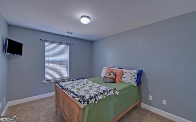 bedroom featuring visible vents, light carpet, and baseboards