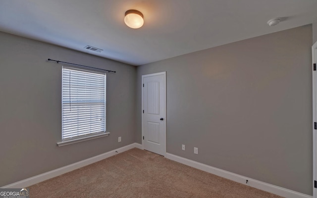 spare room with light carpet, baseboards, and visible vents