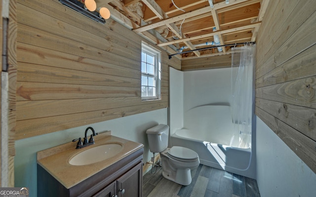 full bathroom featuring toilet, shower / tub combo, wood walls, vanity, and wood finished floors