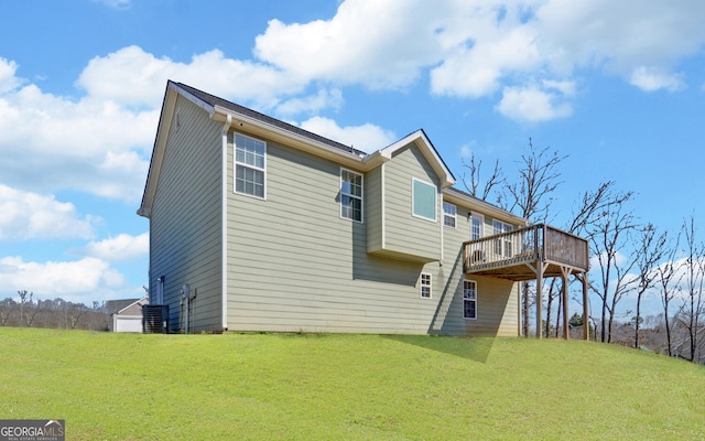 rear view of property with a lawn and a wooden deck