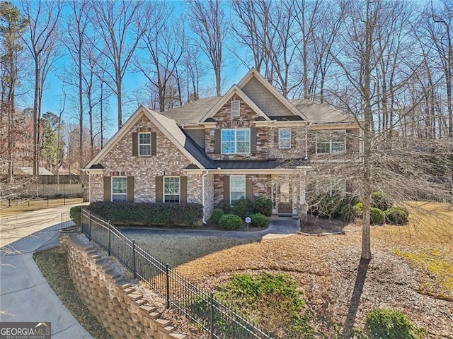 craftsman-style home featuring stone siding and fence