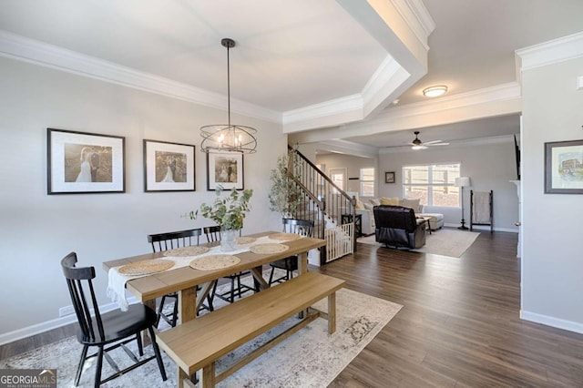 dining area featuring ceiling fan with notable chandelier, baseboards, stairs, dark wood-style floors, and crown molding