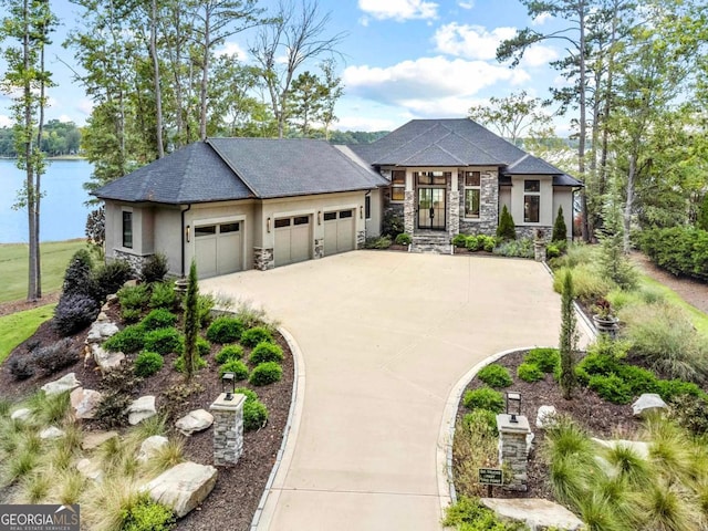 prairie-style home featuring driveway, stone siding, an attached garage, and stucco siding