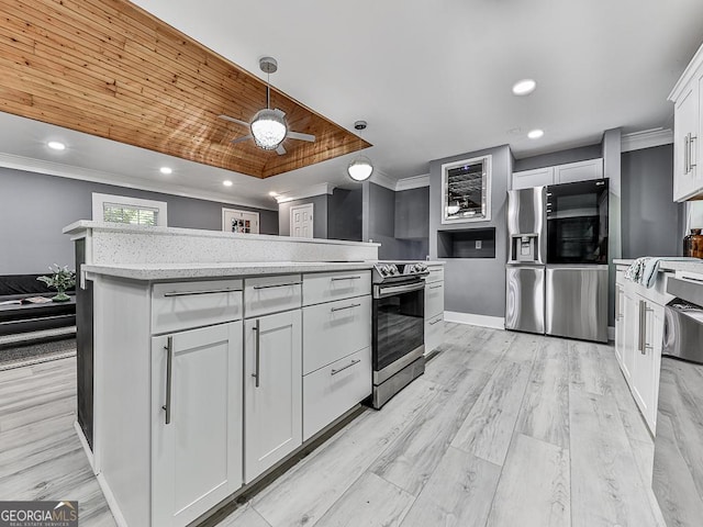 kitchen featuring light countertops, hanging light fixtures, appliances with stainless steel finishes, and white cabinetry