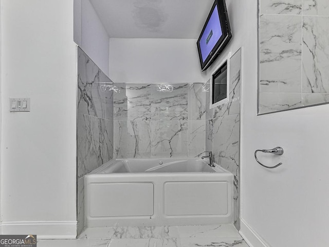 bathroom with marble finish floor, baseboards, and tub / shower combination