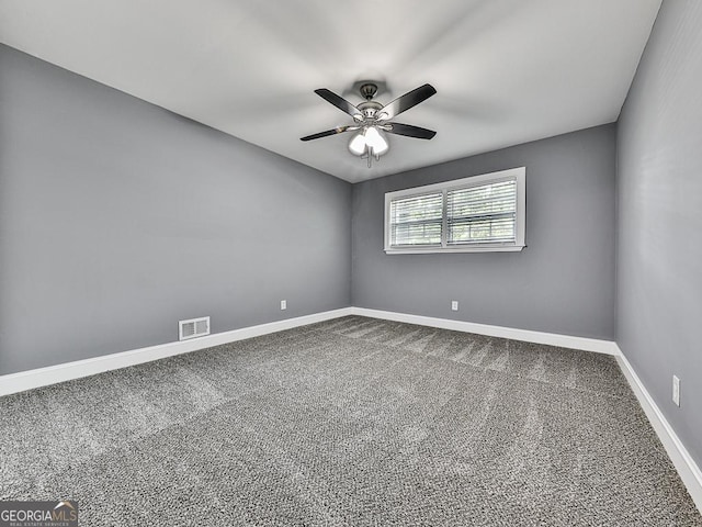 carpeted spare room featuring baseboards, visible vents, and a ceiling fan