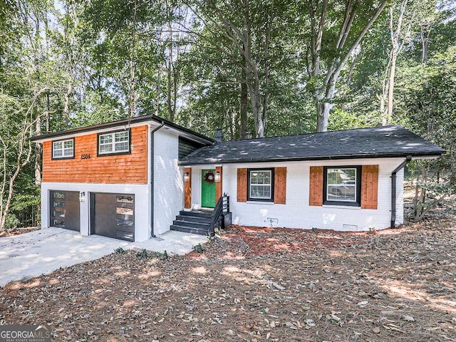 view of front of home featuring a garage, brick siding, and driveway