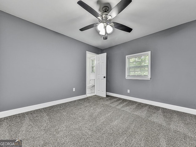 carpeted empty room with ceiling fan and baseboards