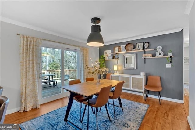 dining area with baseboards, wood finished floors, and ornamental molding