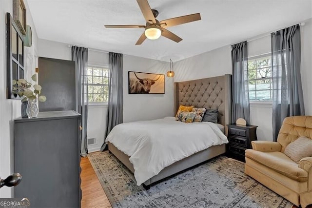 bedroom featuring light wood-type flooring, visible vents, and ceiling fan