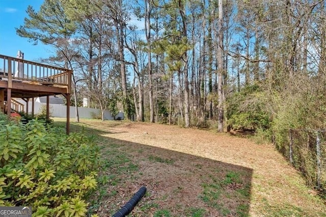 view of yard featuring fence and a deck