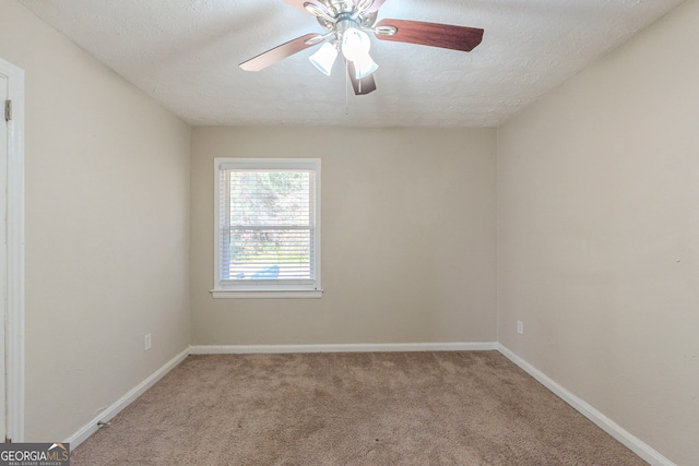 unfurnished room featuring light colored carpet, ceiling fan, a textured ceiling, and baseboards