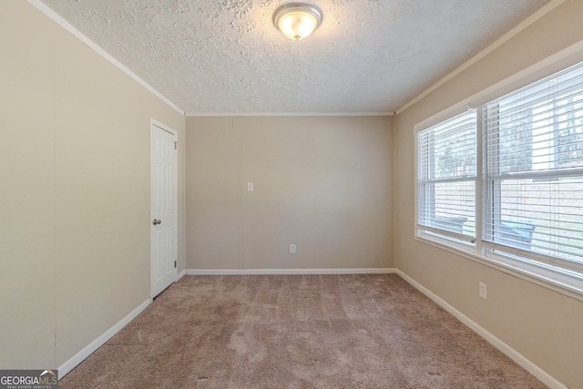 empty room featuring ornamental molding, light carpet, a textured ceiling, and baseboards